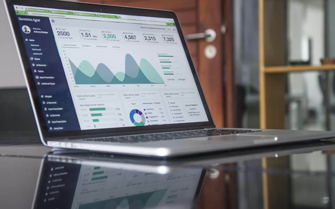 Laptop dashboard showing project metrics and account balance